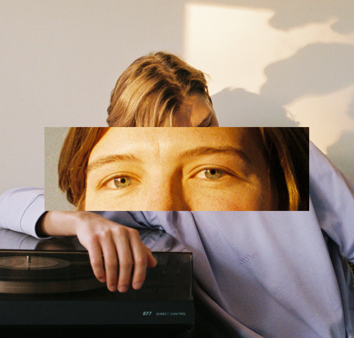 Collage: cropped eyes against a transmasc person sitting and leaning against a record player at golden hour