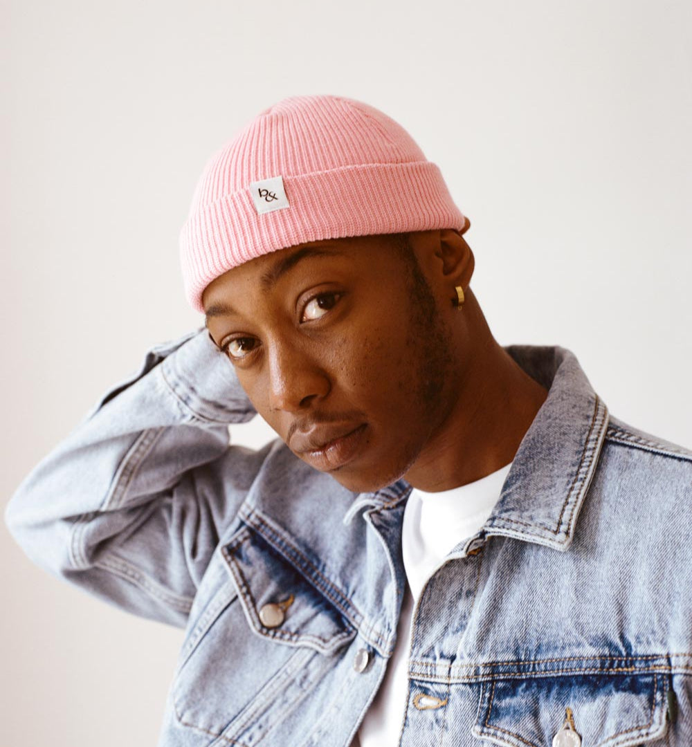 Model with bubblegum pink beanie and light blue denim jacket